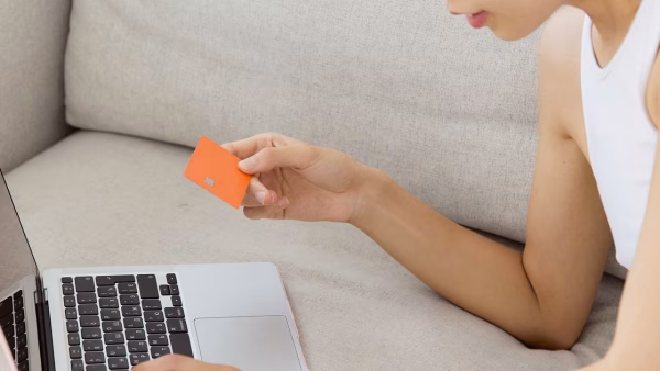 Vrouw met een creditcard koopt online op haar laptop