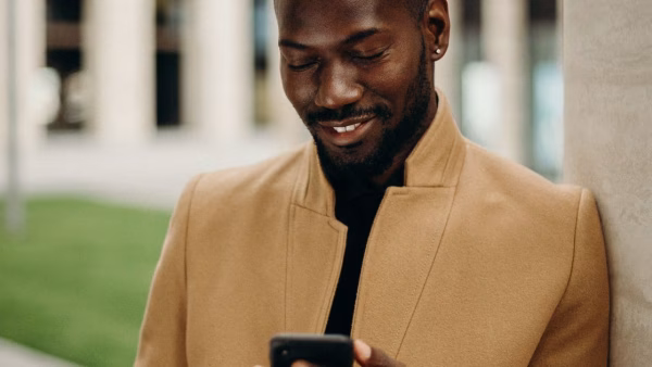Lachende man bekijkt online beoordelingen op zijn smartphone