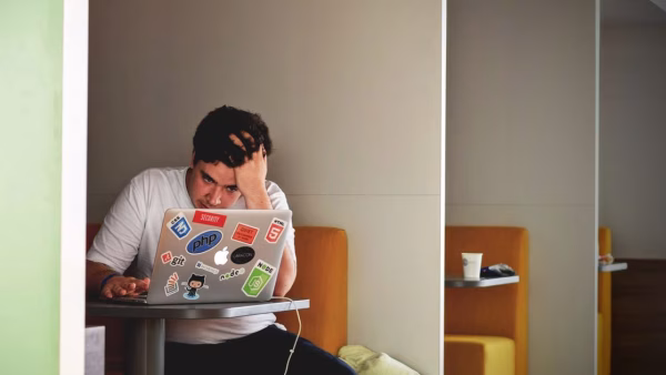 Man kijkt bezorgd naar zijn laptop tijdens het online betalen