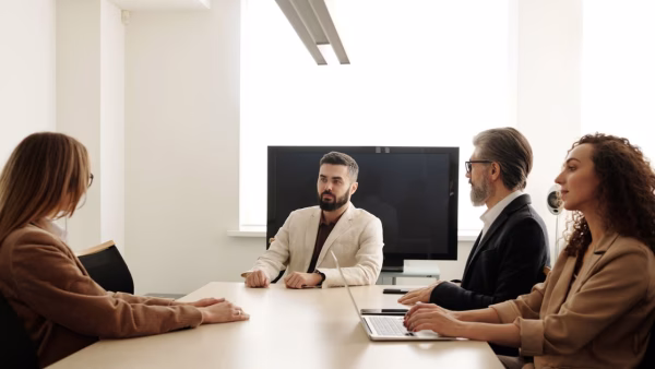 Vier collega's in gesprek tijdens een zakelijk overleg aan tafel