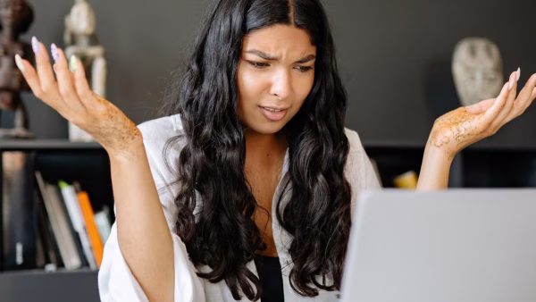 Vrouw kijkt gefrustreerd naar haar laptop tijdens het online winkelen
