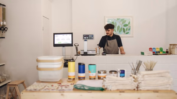 Medewerker achter de kassa in een kleine fysieke winkel