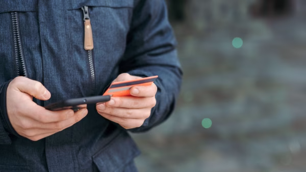 Klant betaalt buiten met een smartphone en creditcard in de hand