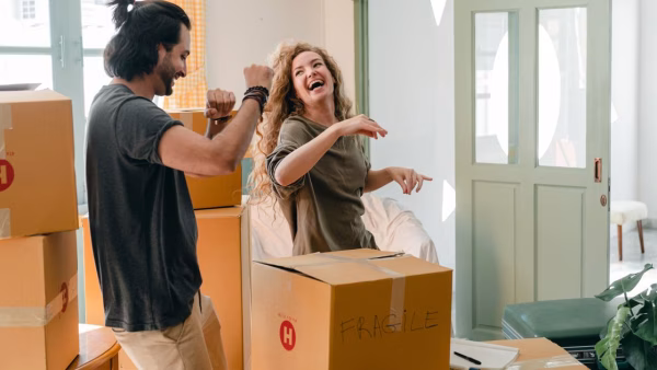 Stel pakt samen enthousiast een pakket uit in de woonkamer