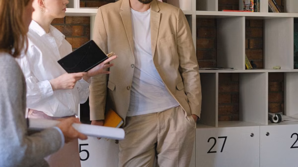Twee collega's overleggen op kantoor terwijl een van hen een tablet vasthoudt