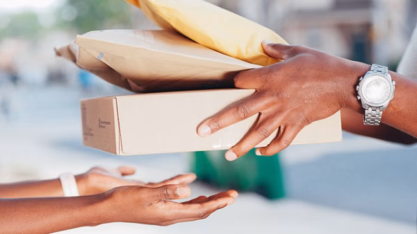 Twee mensen wisselen buiten een pakket uit bij een retourzending