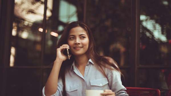 Vrouw gebruikt haar smartphone om te betalen op een terras