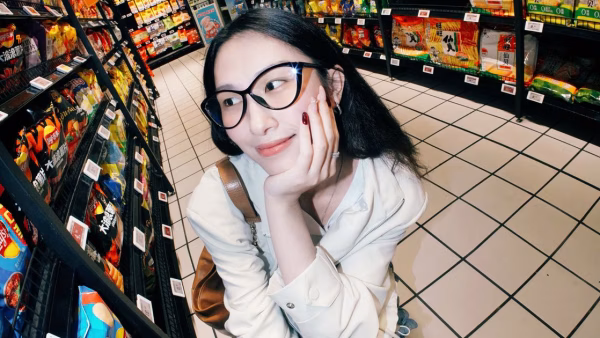 Vrouw bekijkt producten en prijzen in het schap van een supermarkt