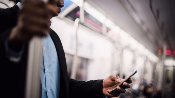 Man bekijkt zijn smartphone tijdens het reizen met het openbaar vervoer