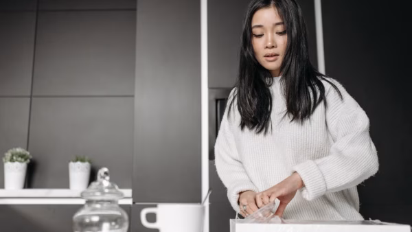 Vrouw pakt een doos uit in een moderne keuken